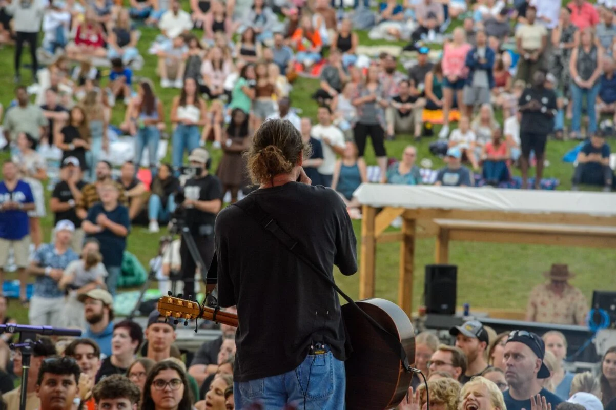 A worship leader on stage facing the crowd at last year's concert